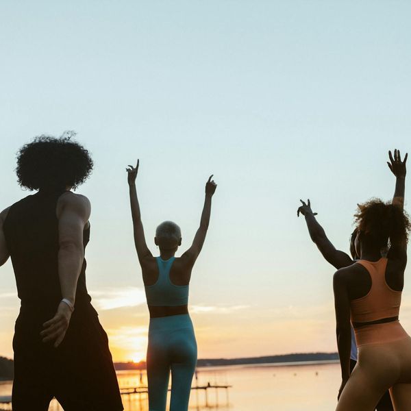 Diverse group of people practicing yoga together outdoors.